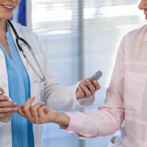 Doctor checking glucose level in diabetic patient in clinic