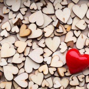 Wooden hearts, one red heart on the heart background.